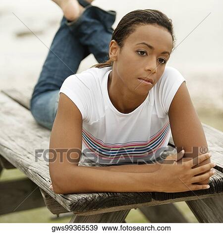 Close-up of a young woman lying on a bench View Large Photo Image Stock Photo - Close-up of a young woman lying on a bench. Fotosearch