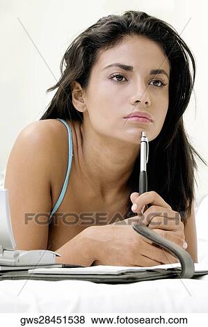 Stock Photo - Close-up of a young woman lying on the bed. Fotosearch
