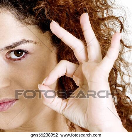 Stock Image - Close-up of a young woman making an ok sign. Fotosearch