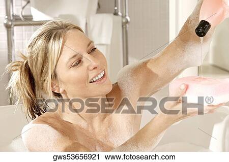 Close-up of a young woman pouring soap on a bath sponge View Large Photo Image Stock Image - Close-up of a young woman pouring soap on a bath sponge. Fotosearch
