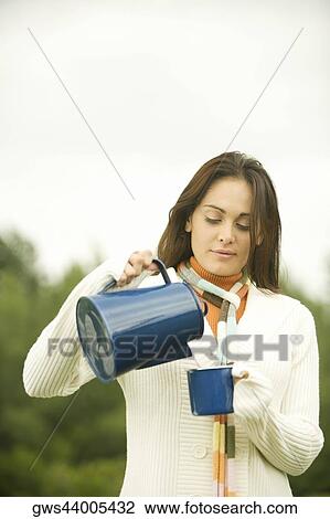 Close-up of a young woman pouring coffee into a cup View Large Photo Image Stock Image - Close-up of a young woman pouring coffee into a cup. Fotosearch