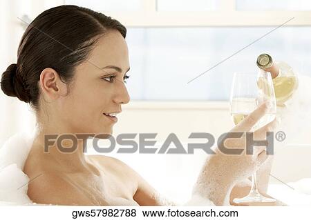 Close-up of a young woman pouring white wine into a wineglass View Large Photo Image Stock Photo - Close-up of a young woman pouring white wine into a wineglass. Fotosearch
