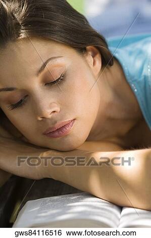 Close-up of a young woman reading a book View Large Photo Image Stock Photograph - Close-up of a young woman reading a book. Fotosearch