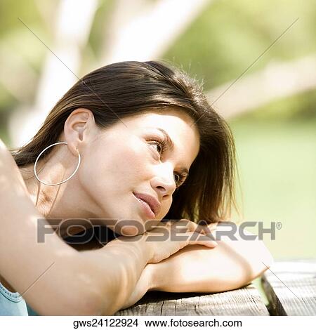 Close-up of a young woman resting on a bench View Large Photo Image Picture - Close-up of a young woman resting on a bench. Fotosearch