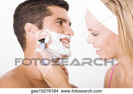 Close-up of a young woman shaving a mid adult man's face View Large Photo Image Picture - Close-up of a young woman shaving a mid adult man's face. Fotosearch