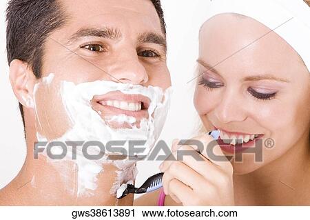 Close-up of a young woman shaving a mid adult man's face View Large Photo Image Stock Image - Close-up of a young woman shaving a mid adult man's face. Fotosearch