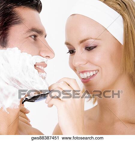 Close-up of a young woman shaving a mid adult man's face View Large Photo Image Stock Image - Close-up of a young woman shaving a mid adult man's face. Fotosearch