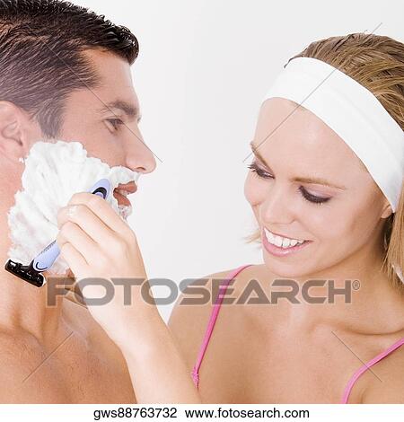 Close-up of a young woman shaving a mid adult man's face View Large Photo Image Stock Image - Close-up of a young woman shaving a mid adult man's face. Fotosearch