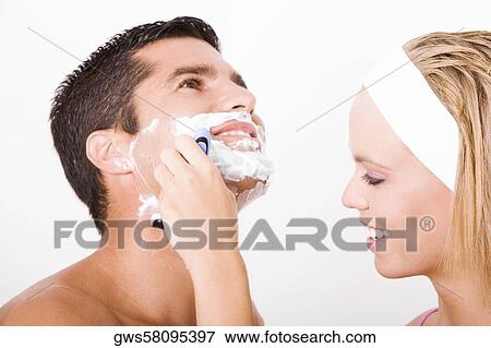 Close-up of a young woman shaving a mid adult man's face View Large Photo Image Stock Photo - Close-up of a young woman shaving a mid adult man's face. Fotosearch