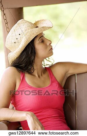 Close-up of a young woman sitting on a porch swing with her eyes closed View Large Photo Image Picture - Close-up of a young woman sitting on a porch swing with her eyes closed. Fotosearch