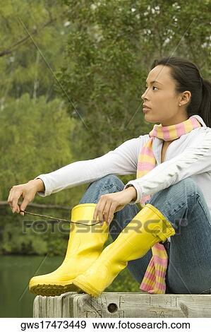 Stock Photo - Close-up of a young woman sitting on a park bench. Fotosearch