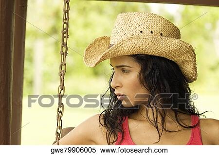 Stock Photography - Close-up of a young woman sitting on a porch swing. Fotosearch