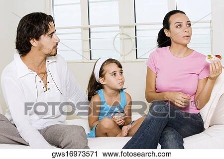 Close-up of a young woman sitting holding a pastry with her daughter and a young man View Large Photo Image Stock Image - Close-up of a young woman sitting holding a pastry with her daughter and a young man. Fotosearch