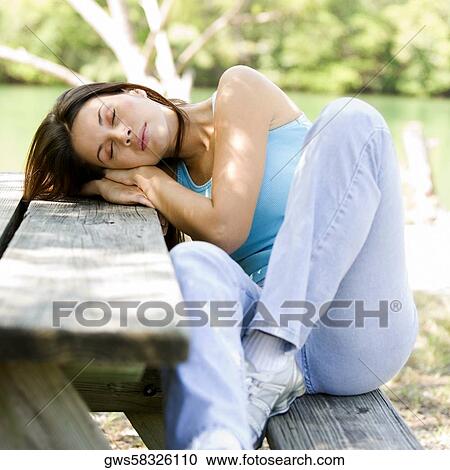 Close-up of a young woman sleeping on a bench View Large Photo Image Stock Image - Close-up of a young woman sleeping on a bench. Fotosearch
