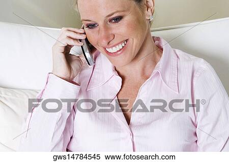 Close-up of a young woman talking on a mobile phone View Large Photo Image Stock Photography - Close-up of a young woman talking on a mobile phone. Fotosearch