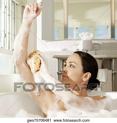 Close-up of a young woman using a bath sponge on her arm View Large Photo Image Stock Image - Close-up of a young woman using a bath sponge on her arm. Fotosearch