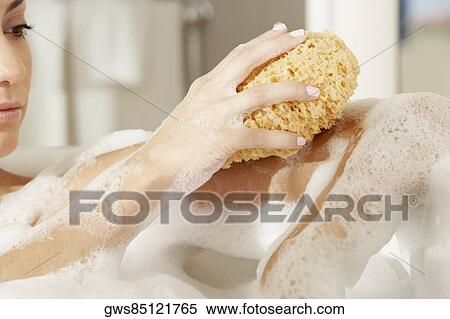 Close-up of a young woman using a bath sponge on her arm View Large Photo Image Stock Photography - Close-up of a young woman using a bath sponge on her arm. Fotosearch