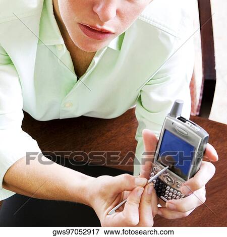 Close-up of a young woman using a personal data assistant View Large Photo Image Stock Photo - Close-up of a young woman using a personal data assistant. Fotosearch