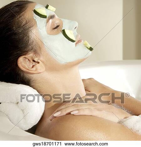 Close-up of a young woman wearing a facial mask in a bathtub View Large Photo Image Stock Image - Close-up of a young woman wearing a facial mask in a bathtub. Fotosearch