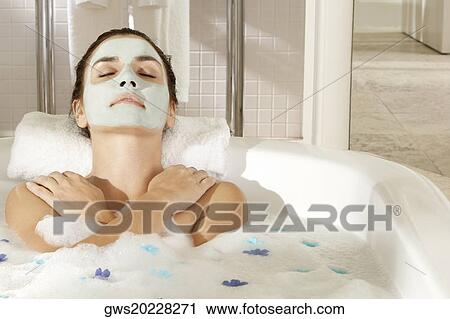 Close-up of a young woman wearing a facial mask in a bathtub View Large Photo Image Stock Image - Close-up of a young woman wearing a facial mask in a bathtub. Fotosearch