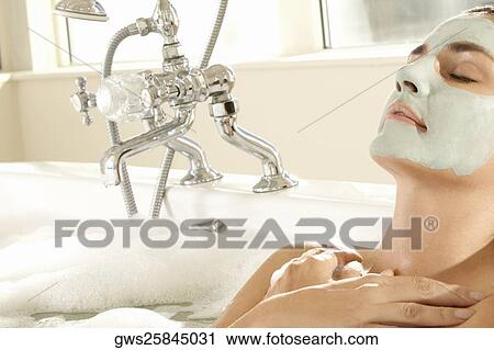 Close-up of a young woman wearing a facial mask in a bathtub View Large Photo Image Stock Image - Close-up of a young woman wearing a facial mask in a bathtub. Fotosearch