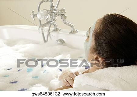 Close-up of a young woman wearing a facial mask in a bathtub View Large Photo Image Stock Image - Close-up of a young woman wearing a facial mask in a bathtub. Fotosearch
