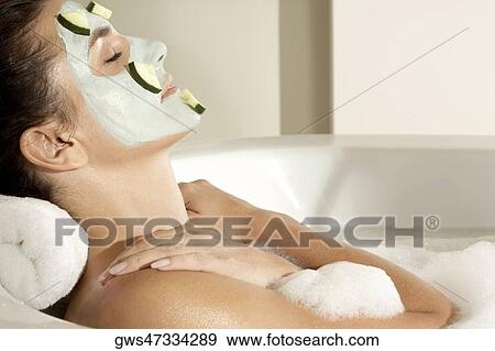 Close-up of a young woman wearing a facial mask in a bathtub View Large Photo Image Stock Photo - Close-up of a young woman wearing a facial mask in a bathtub. Fotosearch