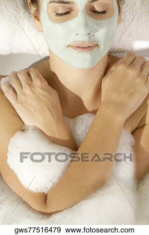 Close-up of a young woman wearing a facial mask in a bathtub View Large Photo Image Stock Photo - Close-up of a young woman wearing a facial mask in a bathtub. Fotosearch