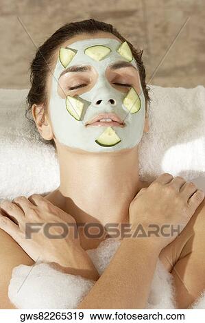 Close-up of a young woman wearing a facial mask in a bathtub View Large Photo Image Stock Photo - Close-up of a young woman wearing a facial mask in a bathtub. Fotosearch