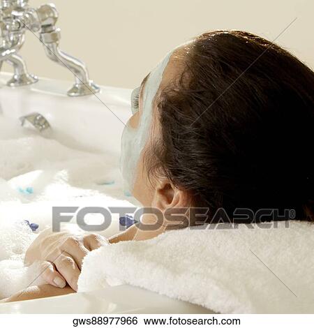 Close-up of a young woman wearing a facial mask in a bathtub View Large Photo Image Stock Photograph - Close-up of a young woman wearing a facial mask in a bathtub. Fotosearch