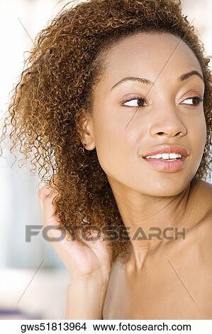 Close-up of a young woman with her hand in her hair View Large Photo Image Picture - Close-up of a young woman with her hand in her hair. Fotosearch
