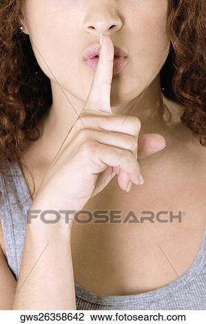 Close-up of a young woman with her finger on her lips View Large Photo Image Stock Image - Close-up of a young woman with her finger on her lips. Fotosearch