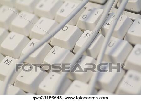 Stock Photography - Close-up of power cables wrapped around a computer keyboard. Fotosearch