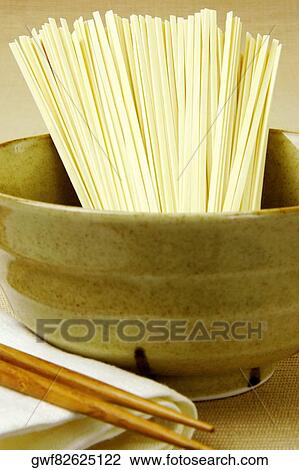 Stock Image - Close-up of raw spaghetti in a bowl. Fotosearch