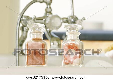 Stock Photograph - Close-up of soap powder and bath pearls in glass bottles. Fotosearch