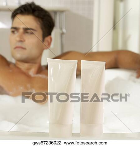 Close-up of two bottles of moisturizer with a young man in a bathtub behind it View Large Photo Image Stock Image - Close-up of two bottles of moisturizer with a young man in a bathtub behind it. Fotosearch