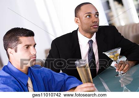 Close-up of two businessmen sitting at a bar counter View Large Photo Image Stock Image - Close-up of two businessmen sitting at a bar counter. Fotosearch