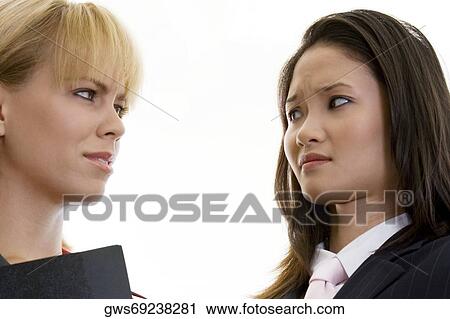 Close-up of two businesswomen looking at each other View Large Photo Image Stock Image - Close-up of two businesswomen looking at each other. Fotosearch