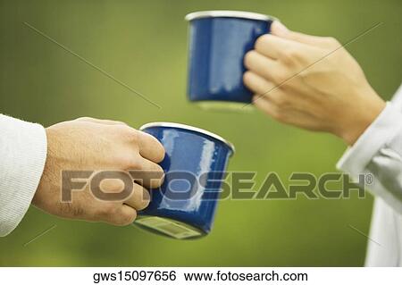 Close-up of two human hands holding coffee cups View Large Photo Image Stock Photograph - Close-up of two human hands holding coffee cups. Fotosearch