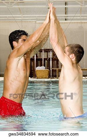 Close-up of two young men cheering in a swimming pool View Large Photo Image Picture - Close-up of two young men cheering in a swimming pool. Fotosearch