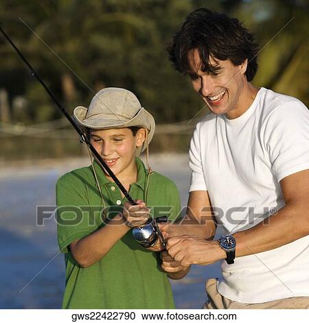 Father and his son fishing on the beach View Large Photo Image Stock Image - Father and his son fishing on the beach. Fotosearch