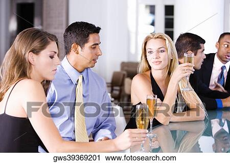 Stock Image - Five people sitting at a bar counter. Fotosearch