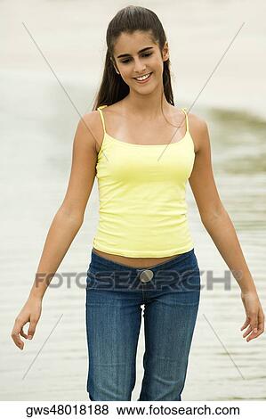 Stock Photo - Girl standing on the beach. Fotosearch