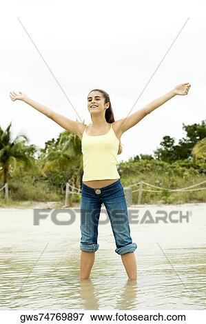 Girl standing on the beach with her arms outstretched View Large Photo Image Stock Photo - Girl standing on the beach with her arms outstretched. Fotosearch