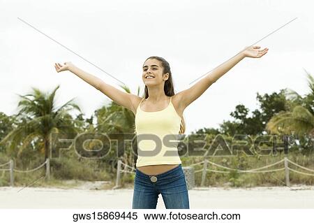 Girl standing on the beach with her arms outstretched View Large Photo Image Stock Photography - Girl standing on the beach with her arms outstretched. Fotosearch