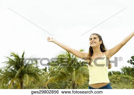 Girl standing with her arms outstretched View Large Photo Image Stock Photograph - Girl standing with her arms outstretched. Fotosearch