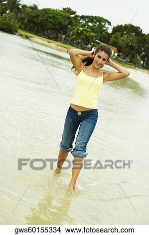 Girl wading in water on the beach View Large Photo Image Picture - Girl wading in water on the beach. Fotosearch