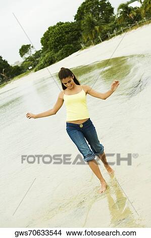 Girl wading in water on the beach View Large Photo Image Picture - Girl wading in water on the beach. Fotosearch