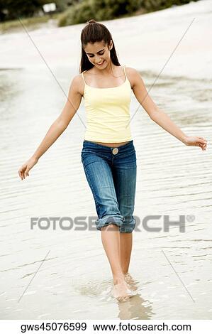 Girl wading in water on the beach View Large Photo Image Stock Photo - Girl wading in water on the beach. Fotosearch