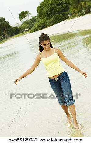 Girl wading in water on the beach View Large Photo Image Stock Photo - Girl wading in water on the beach. Fotosearch